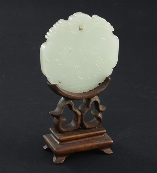 A Chinese pale celadon jade plaque, 19th century, 5.9cm, wood stand